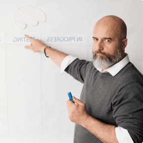 A man writing on a whiteboard