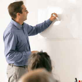 A man writing on a whiteboard